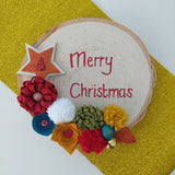 Decorative Christmas card with colorful flowers and 'Merry Christmas' text on a gold background.