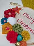 Colourful Christmas-themed sign with flowers and text on a white background